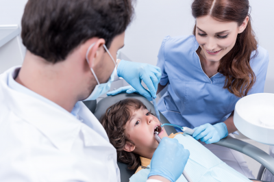 dentista e assistente tratando uma criança